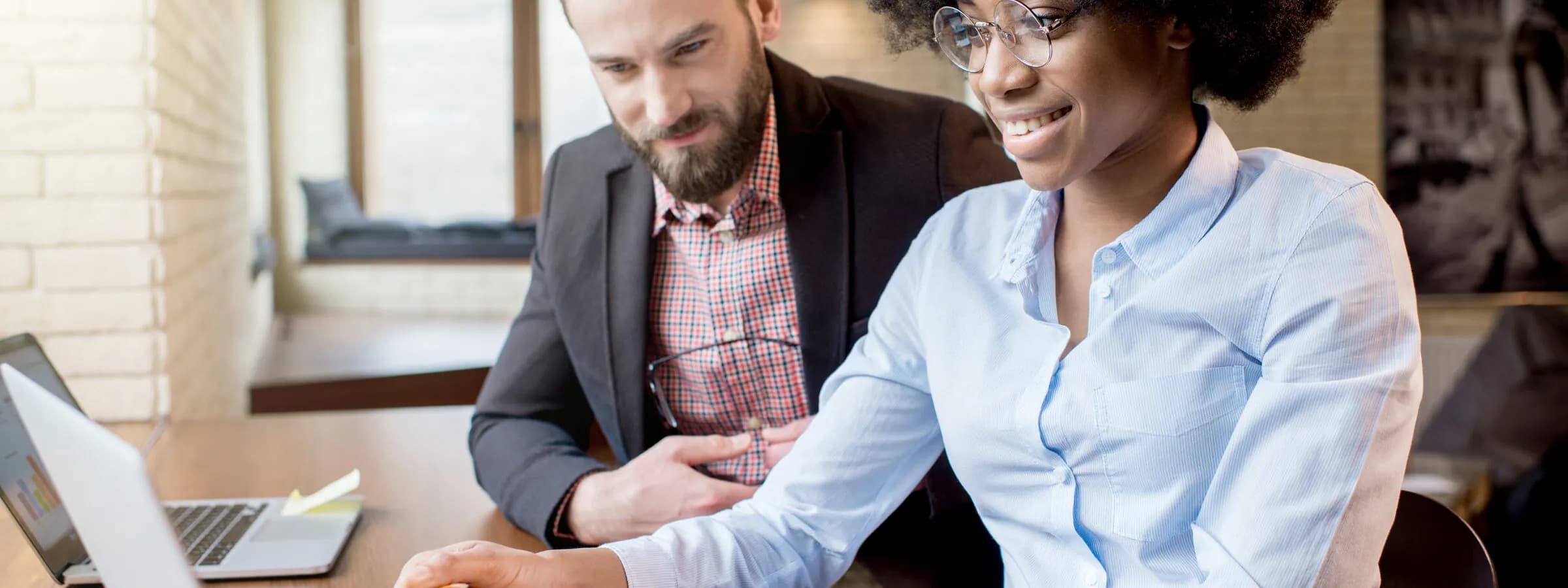 Two colleagues working together at a laptop