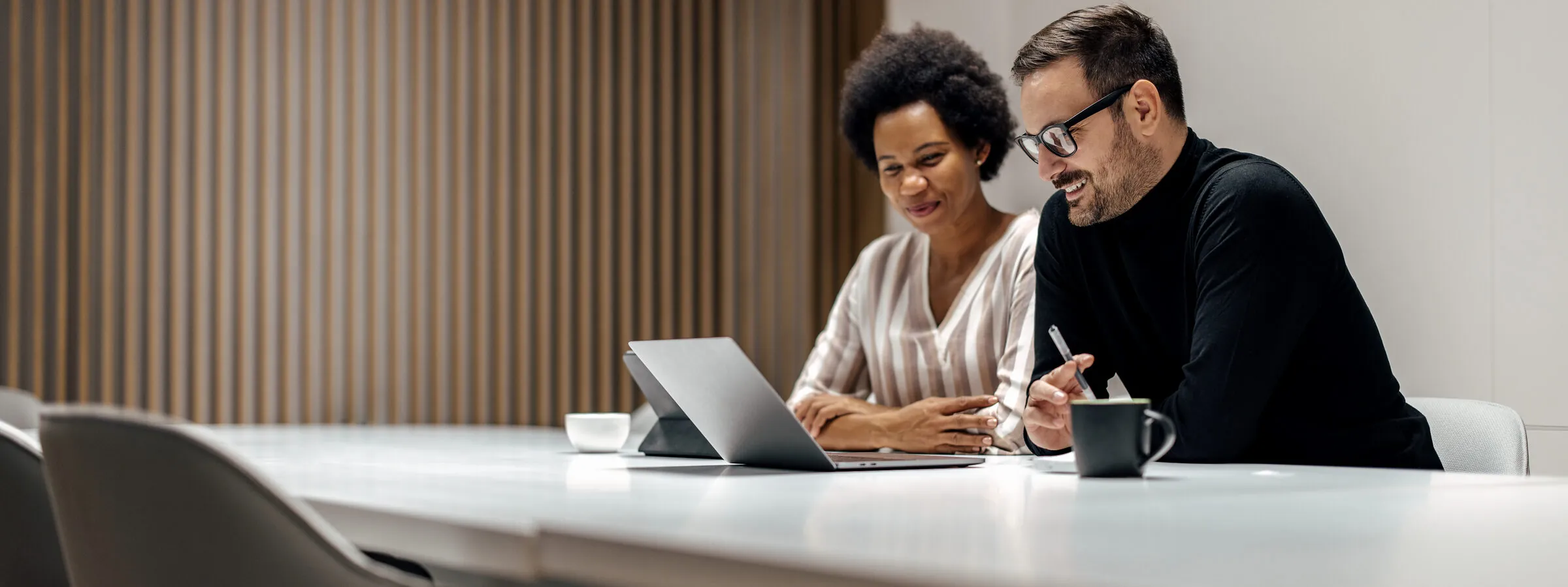 Two colleagues reviewing a document together at a desk
